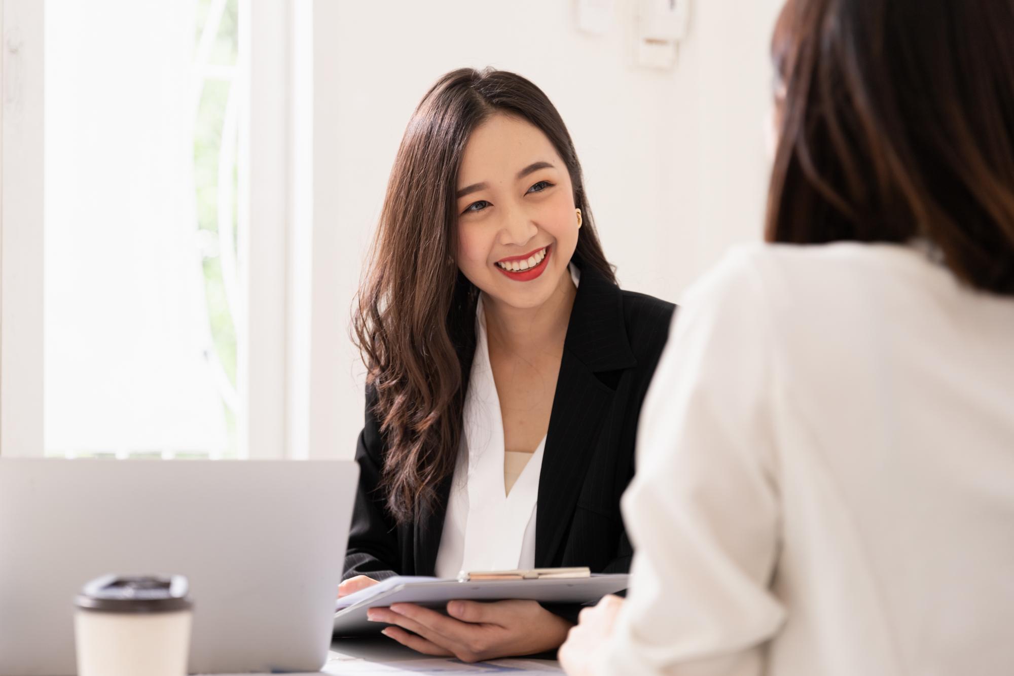 A young attractive asian woman is interviewing for a job. Her interviewers are diverse. Human resources manager conducting job interview with applicants in office